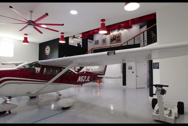 red airplane parked in residential hangar home garage with living space