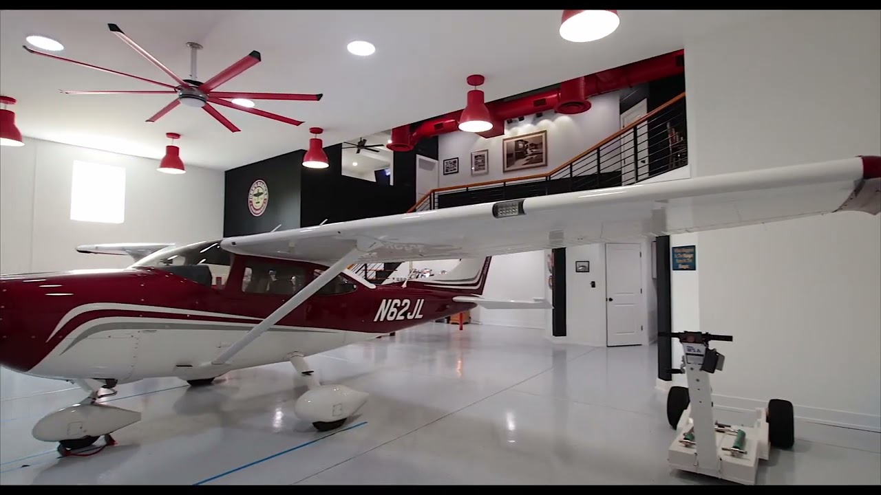 red airplane parked in residential hangar home garage with living space