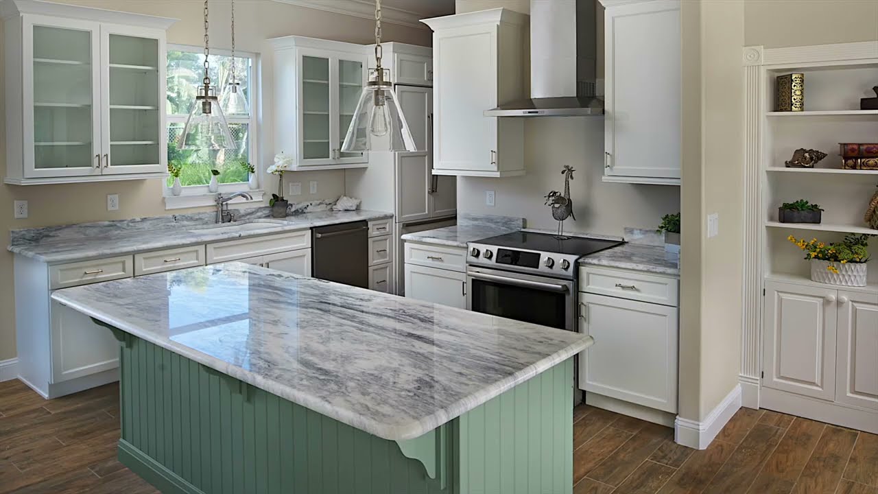 kitchen with marble countertop island, white cabinets with glass panel doors and light green accent color on several cabinet bases