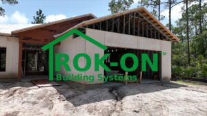 Rok On Building systems logo shown over image of steel kit home with panels installed