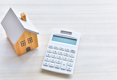 small toy home paced next to a calculator on a tabletop